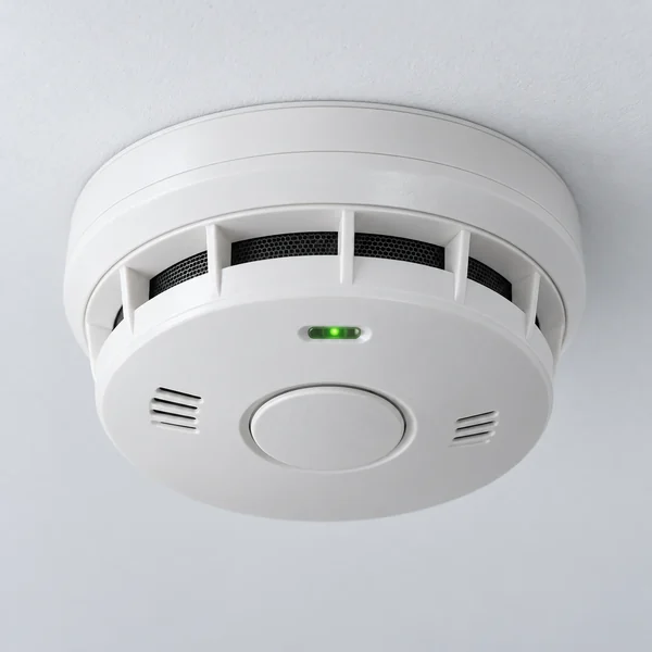 A white smoke alarm on a ceiling
